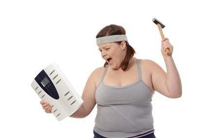 Overweight Woman Hitting Weight Scale WIth Hammer